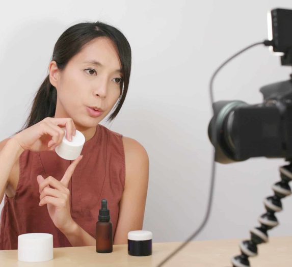 Woman taking video for beauty product at home